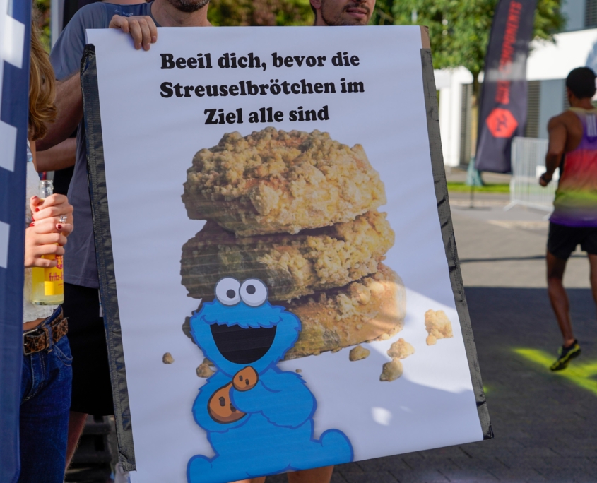 Schild: "Beeil dich, bevor die Streuselbrötchen im Ziel alle sind"